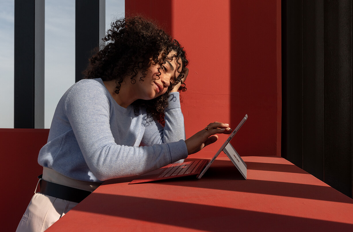 一位女性触控 Surface Pro 7 的屏幕