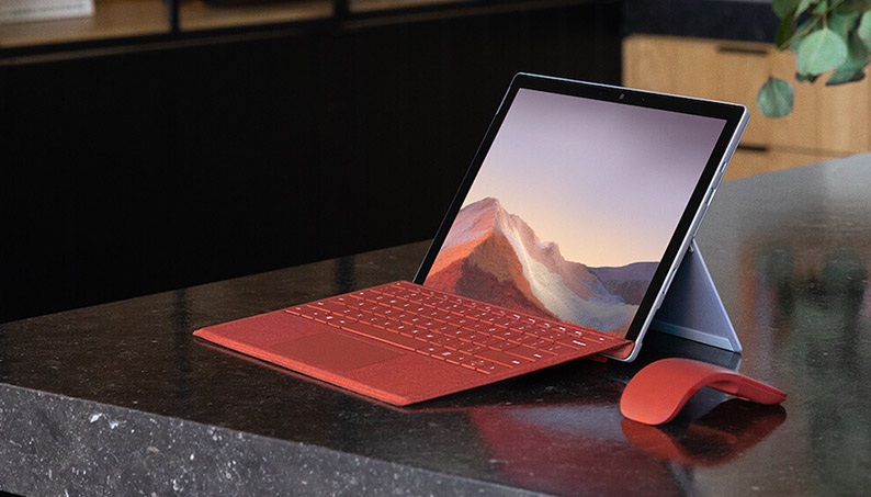 桌子上的 Surface Pro 7 搭配键盘盖和 Arc 鼠标
