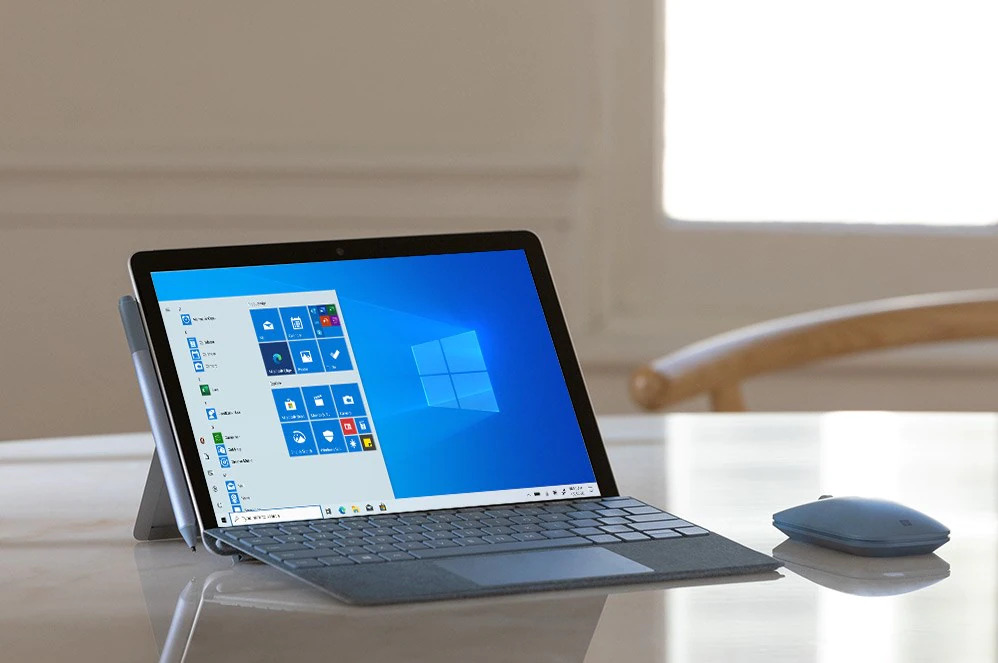 带有移动鼠标的 Surface Go 2 放在桌子上，屏幕上显示着 Windows 10 Gmunk 开始屏幕