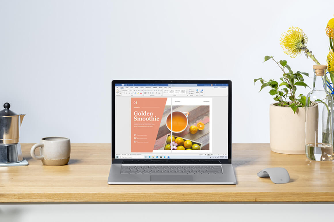 Surface Laptop 4 商用版置于桌上，周围放置着鼠标、杯子和花瓶等。