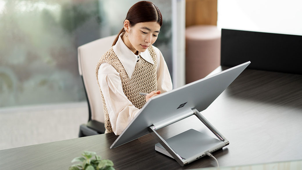 一个人使用 Surface 触控笔在 Surface Studio 2+ 商用版的屏幕上工作。