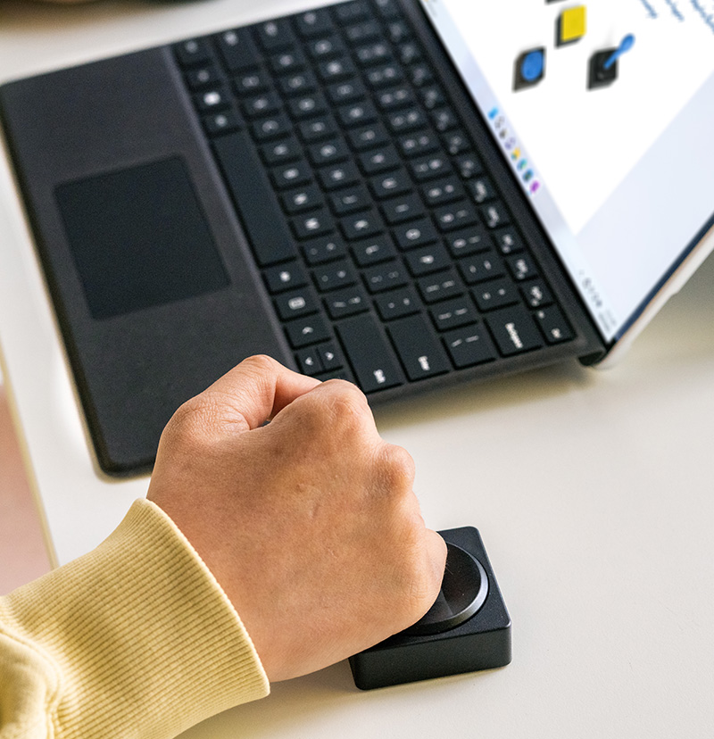 一个人在使用与 Surface 设备搭配的 Microsoft 自适应方向键按钮。