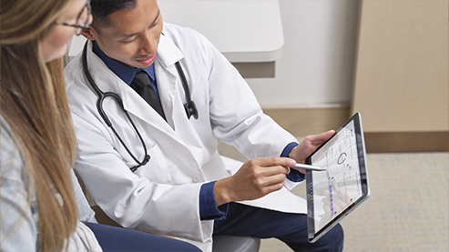 医生在与患者交谈时使用 Surface 触控笔商用版与 Surface Go 4 商用版的触控屏进行交互。