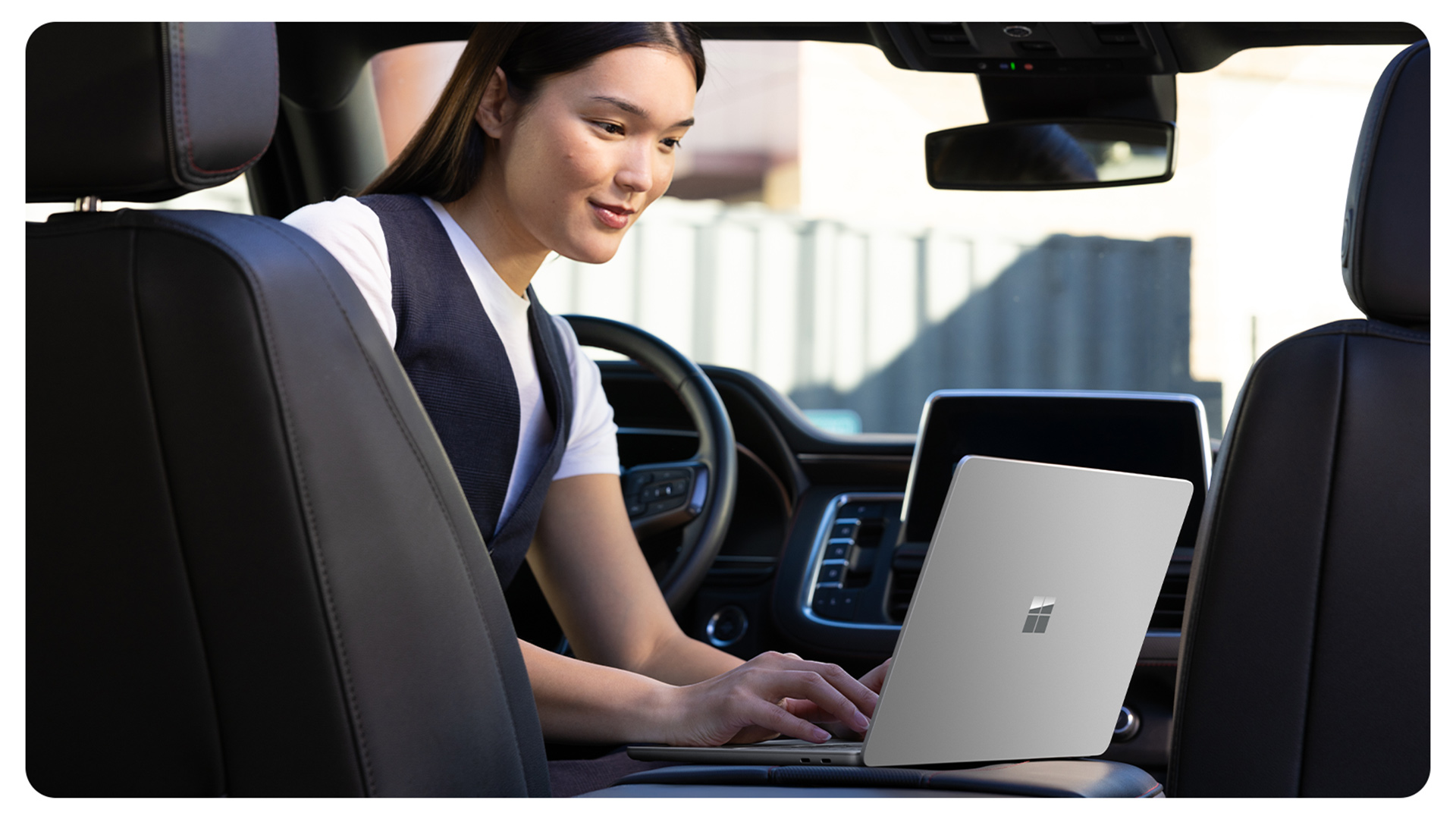 一位停留在车内的人正在使用 Surface Laptop 商用版,展示了防反射屏幕如何让人在各种环境中都能轻松使用该设备。