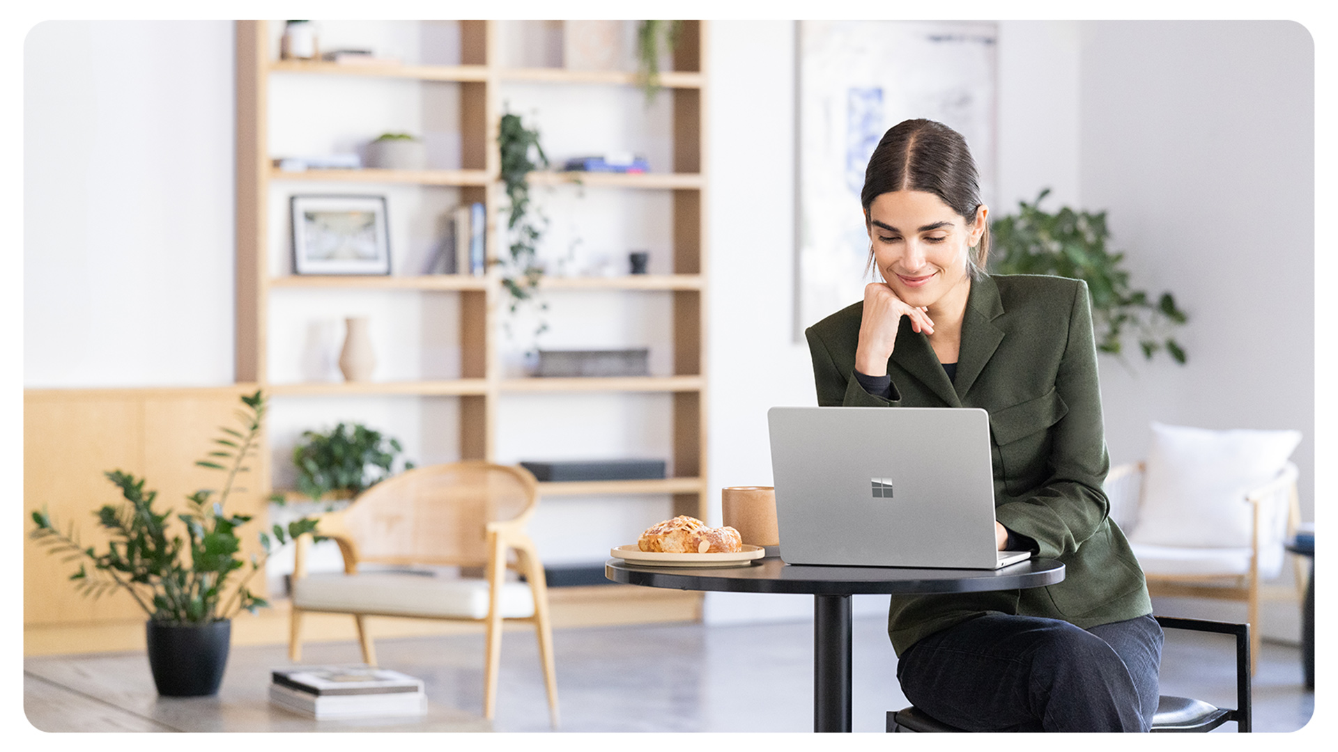 一个人在微笑着使用 Surface Laptop 商用版,展示了该设备显示屏无闪烁且可减少蓝光暴露,带来舒适的使用体验。